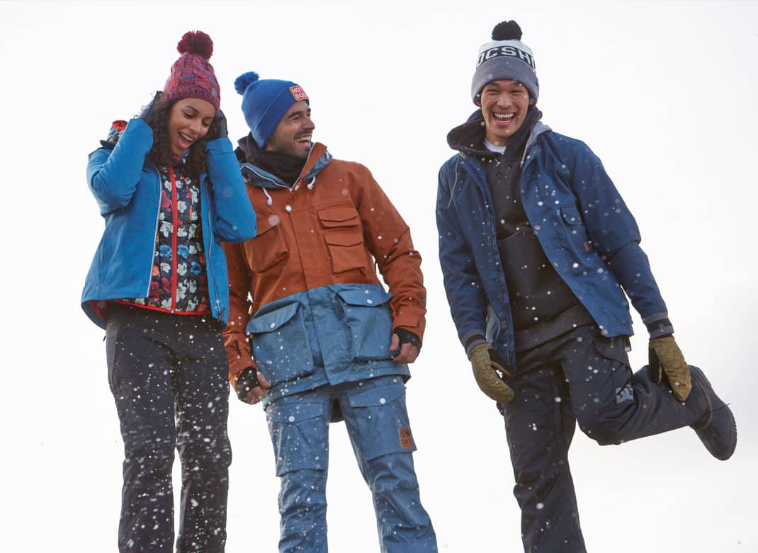Trois personnes heureuses de porter leur manteau d'hiver